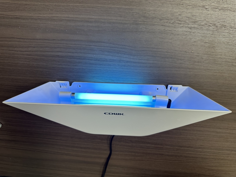Close-up of the high-viscosity glue board and dual Philips UV lamps inside the ABS-B trap